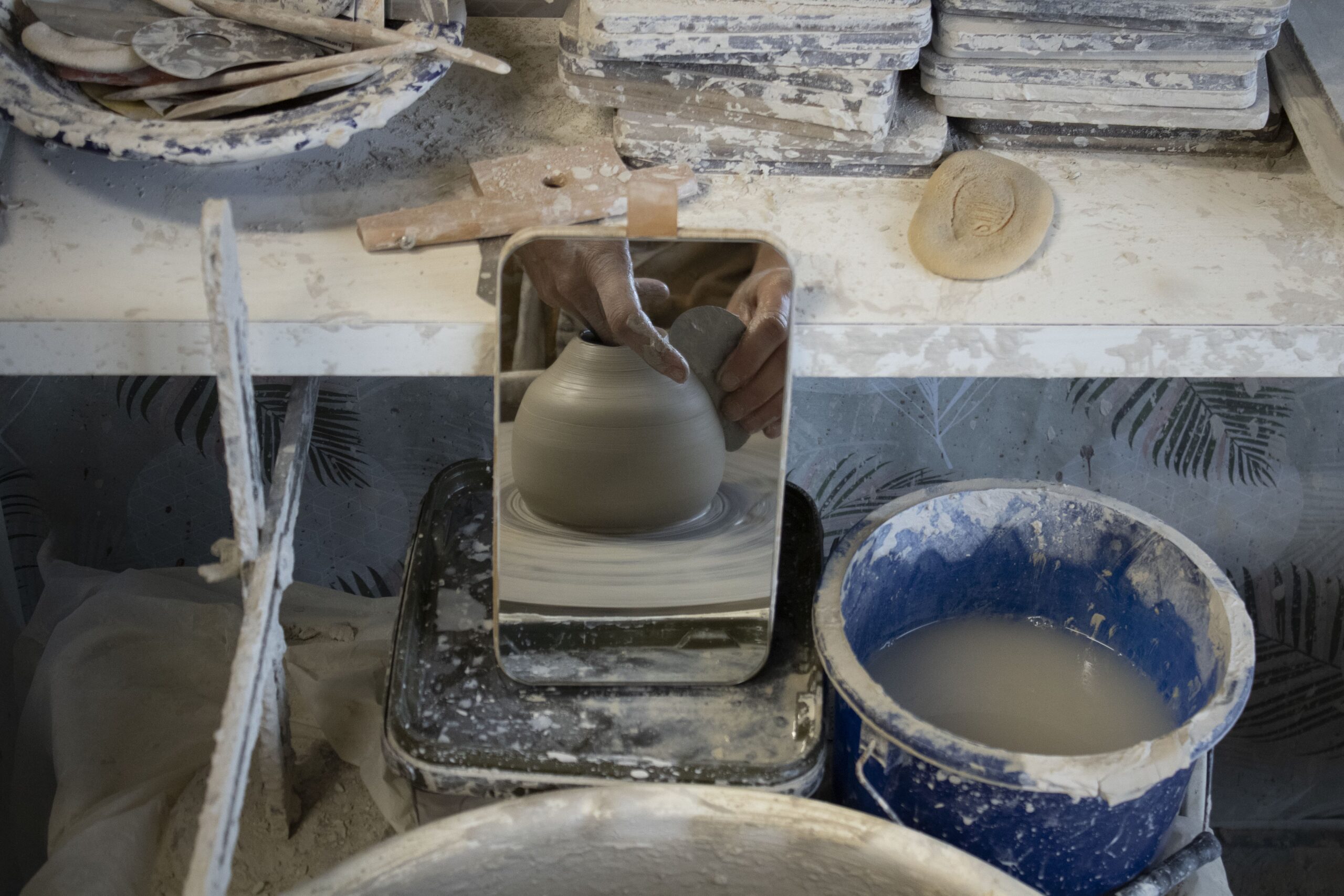 Carole Cioni de l'Atelier Céramique en train de tailler ses pièces en grès blanc