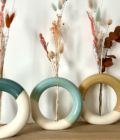 Vase donuts en céramique artisanal, décliné en plusieurs couleurs, idéal pour sublimer des compositions de fleurs séchées. Design moderne et arrondi en grès blanc, parfait pour une décoration intérieure naturelle et élégante
