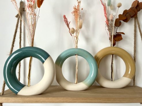 Vase donuts en céramique artisanal, décliné en plusieurs couleurs, idéal pour sublimer des compositions de fleurs séchées. Design moderne et arrondi en grès blanc, parfait pour une décoration intérieure naturelle et élégante